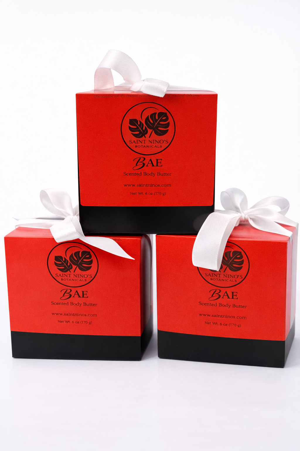 Saint Nino’s Botanicals BAE scented body butter packaging in red and black with botanical logo and ribbon